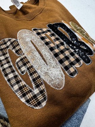 Close-up of plaid and sequin GOBBLE letters on brown sweatshirt