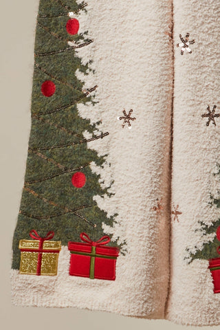 Detail of Christmas tree and gift design on sweater pants