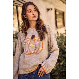 Close view of embroidered pumpkin with flowers on oatmeal sweater