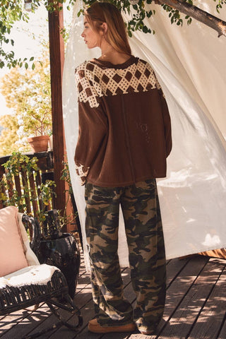 Camo wide-leg pants with white floral applique styled with a brown waffle top