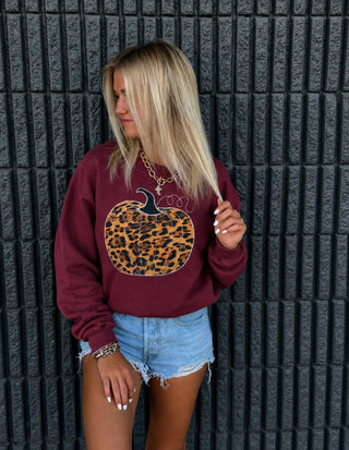 Harvest Festival maroon crewneck sweatshirt with leopard print pumpkin applique, styled with denim shorts