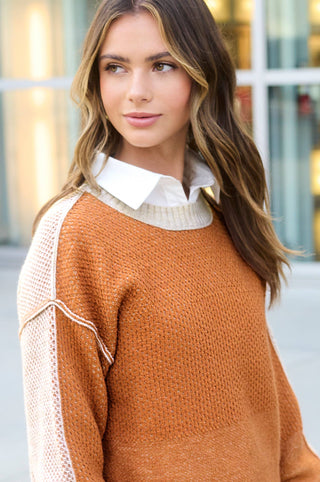 Ginger color block sweater layered over a white collared shirt with light-wash jeans