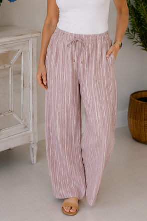 Person wearing pink striped pants in a home setting