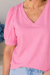 Person wearing a pink top with a blurred background