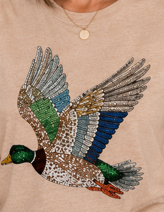 Beige shirt with a colorful duck design on a beige background