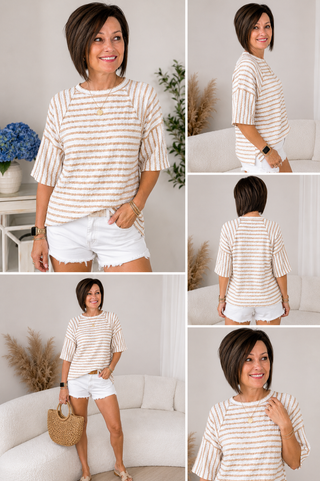 Woman wearing a striped shirt and white shorts in a home setting