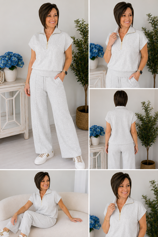 Woman in a white outfit posing in a room with plants and furniture.