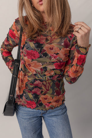 Rust, olive and crimson floral mesh top shown with hand at shoulder