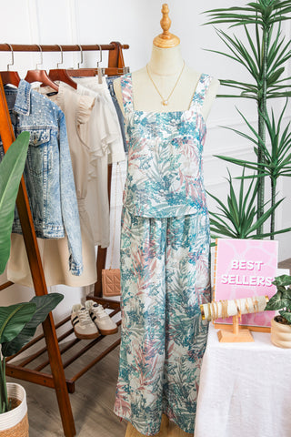 Mannequin wearing a floral outfit with a clothing rack and 'Best Sellers' sign in the background.