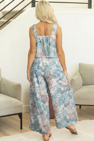 Woman wearing a floral jumpsuit in a living room setting