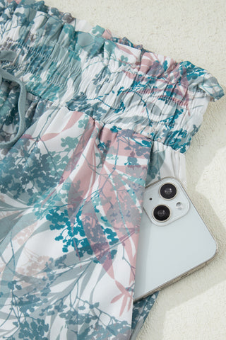Floral-patterned fabric with a smartphone underneath on a light background
