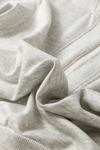 Close-up of a light gray fleece fabric with a zipper