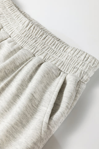 Close-up of light gray sweatpants on a white background