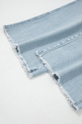 Light blue denim fabric with frayed edges on a white background