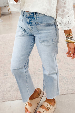 Light blue jeans worn by a person on a light-colored floor.