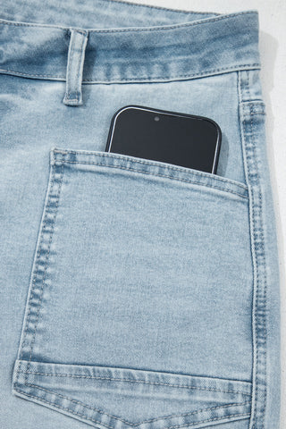 Smartphone in the pocket of light blue jeans on a white background