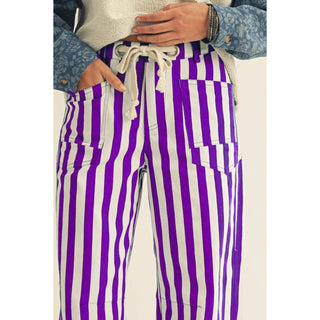Close-up of rope string waist and front pockets on purple striped pants