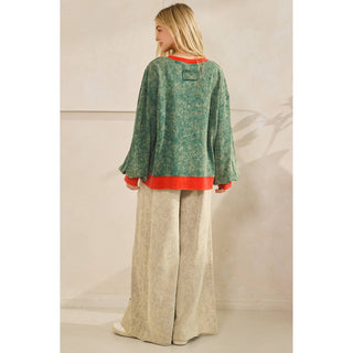 Back view of oversized green mineral wash pullover with red ribbed hem