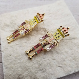 Side view of pink nutcracker Christmas earrings