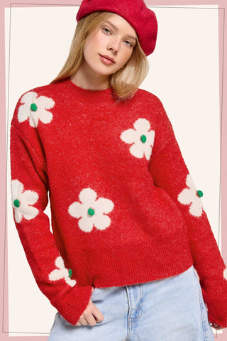 Red daisy sweater styled with light-wash jeans and a red beret