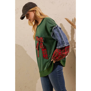 Side view of green pullover with red plaid bow and denim sleeves