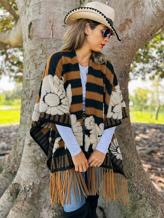 Side view of fringe ruana draped over a long sleeve top