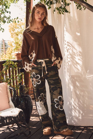 Close-up of floral and crochet lace patches on camo pants